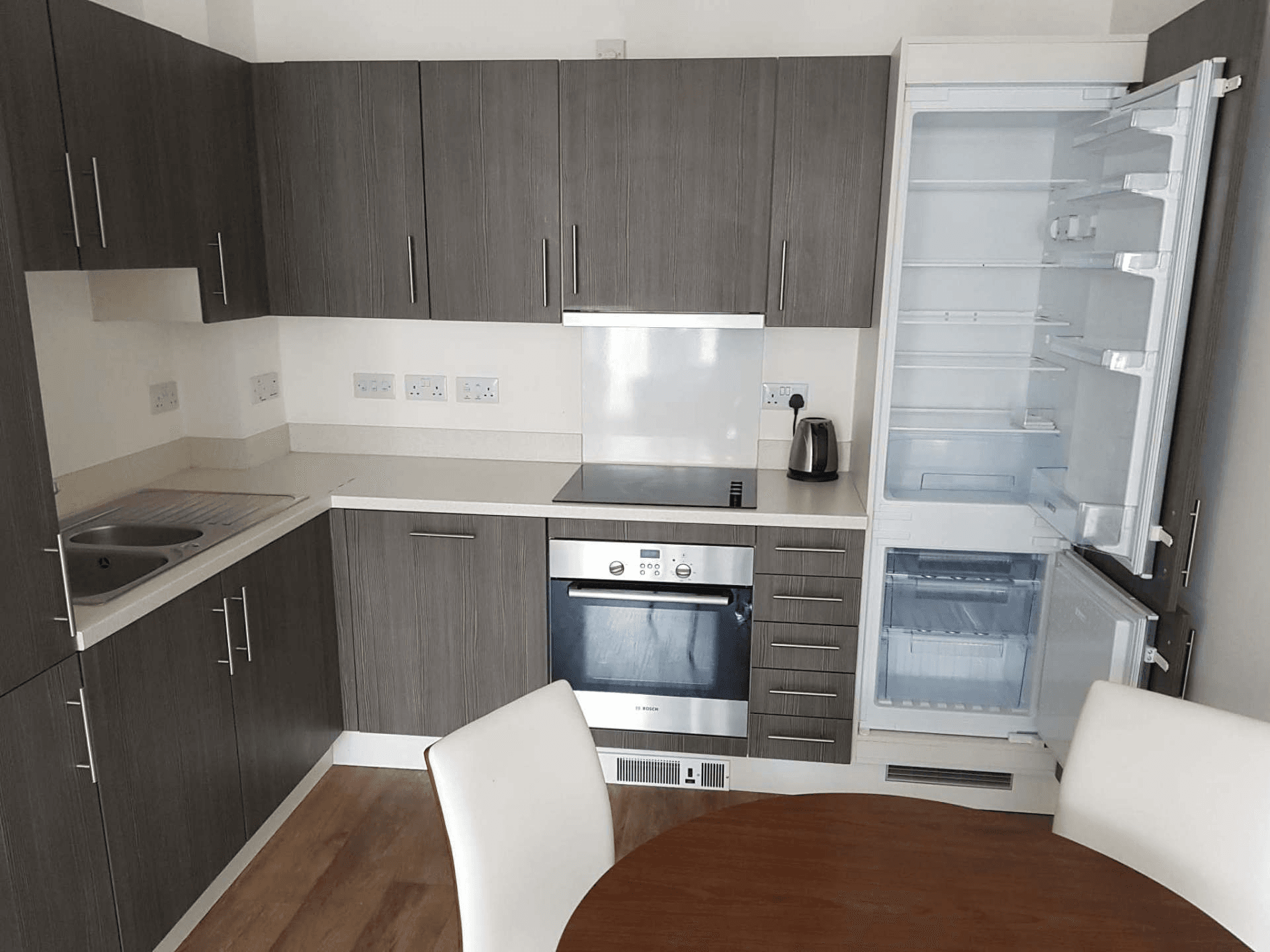 Grey kitchen with fridge-freezer fully cleaned inside and out for end of tenancy